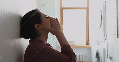 Depressed stressed young Indian lady sit alone by white wall