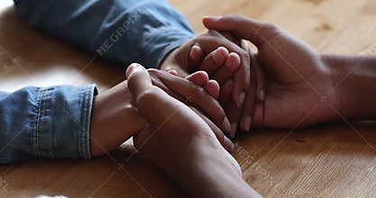Closeup young Black husband hold wife hands comfort give support