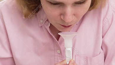 a woman collects saliva in a container for a dna test.