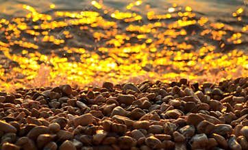Pebbles and sea at sunset