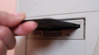 Insert a floppy disk into a vintage PC. Drive to read information packs to work, retro computers