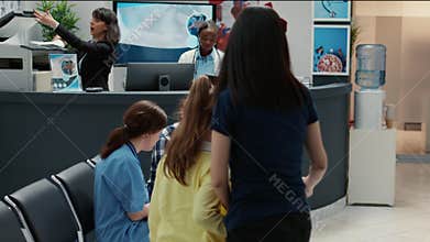 Medical assistant chatting with asian man and taking notes