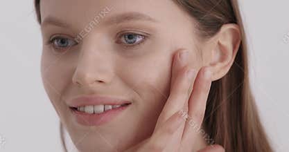 Face skin care. Woman applying cosmetic serum on face skin