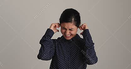 Indian woman cover ears with hands annoyed by noise