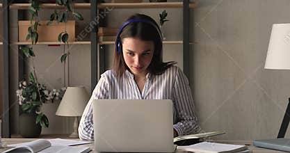 Female student studying, listen audio course through headphones