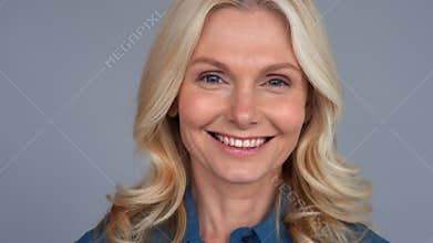 Smiling attractive 50s middle aged blond business woman looking at camera.