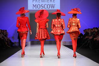 Backs of four women walk the catwalk