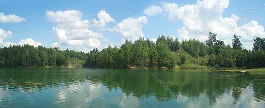 Summer landscape panorama with trees near quiet lake