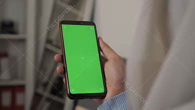 Close up image of smart phone mockup, woman holding phone with green screen