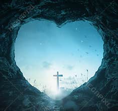 Spiritual Christian Cross Silhouette Seen Through Heart Shaped Cave Entrance at Dawn