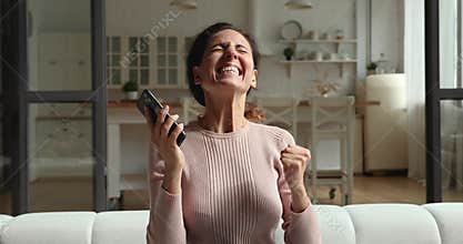 Excited young woman winner celebrate mobile online betting victory