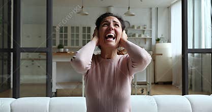 Woman cover ears with hands annoyed by noisy neighbors