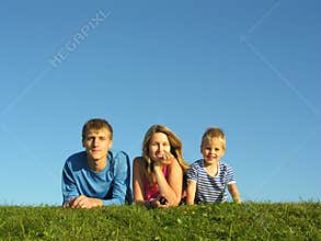Family on herb under blue sky