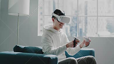 Amazed man in white VR headset moves controllers and smiles