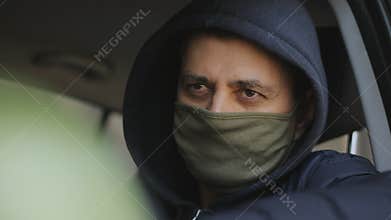 A spy or private detective secretly takes photos of illegal actions from the window of his car.