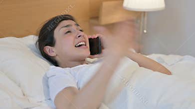 Angry Young Indian Woman Talking on Phone in Bed