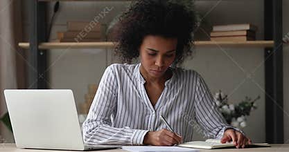 African woman learn paperwork with graphs writes notes in sketchpad