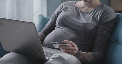 Happy pregnant woman buying baby products online