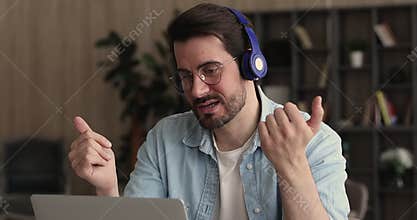 Focused young man in headphones holding video call zoom meeting.