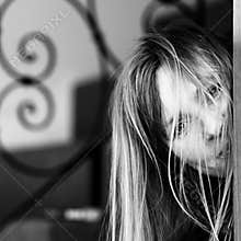 Curious facial expression of woman looking around corner to photographer