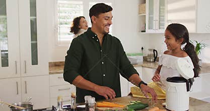 Hispanic parents and daughter cooking and teaching segregating bio trash
