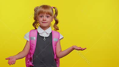 Smiling cute schoolgirl kid with backpack looking at copy space for promotional content holding hand