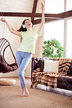 Vertical full length body size view of attractive cheerful ecstatic girl listening music free time having fun at house