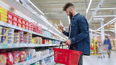 buying cheese in supermarket, man is checking shelf life, reading labels