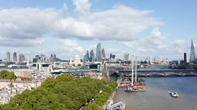 Aerial view of green trees in Temple Gardens on bank of River Thames. Modern office buildings in background. London, UK