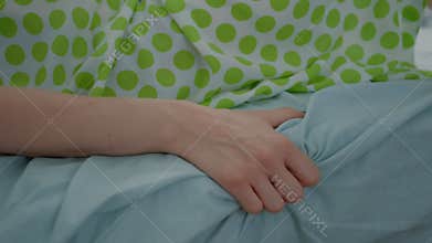Close up of pregnant woman hand holding bed