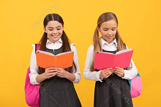 Little children in school uniforms read library books yellow background, reading