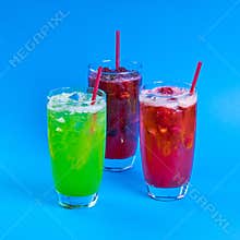 red and green fresh cocktails smoothie jusice in glass with ice on blue background. vitamin drink detox