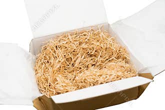 Shredded white paper cushioning in cardboard box