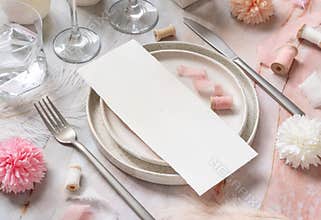 Wedding Table place with a card near pink flowers, feathers and silk ribbons, menu mockup