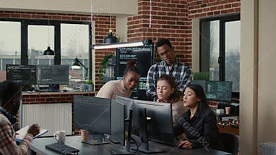 Software engineers brainstorming ideas looking at code on computer screens asking feedback