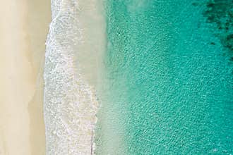 Beach and azure sea with waves from top view