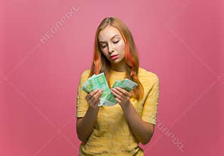 Pensive young girl counting cash thinking about finding money for paying bills. Financial problems and bankruptcy