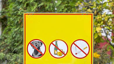 Three prohibiting red signs on a yellow background. No dog, no smoking, no drinks signs.