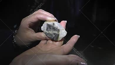 Woman holding mineral in the dark mine