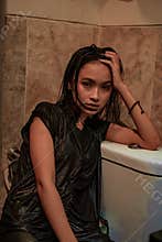Hot and wet Asian girl poses with sensual style while wearing black wet dresses