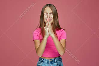Capricious child girl do praying gesture ask for apology, pocket money, permission, apologize for bad behaviour