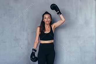 Woman wearing boxing gloves jokingly threatens to beat