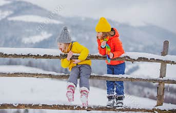 Winter children girl and boy enjoying winter. Children play outdoors in snow. Outdoor fun for kids Christmas vacation.