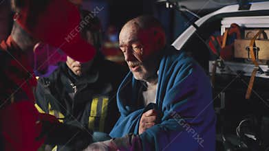 Senior survivor speaking to emergency service workers