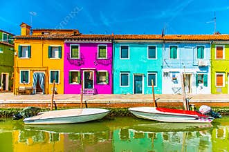 Narrow street with blue, red, green and purple house facade in the island of Burano, Venice