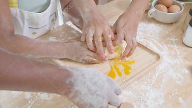 Closeup hands of African American family with daughter add egg to flour and thresh for cooking with father and mother together.