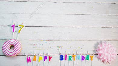 Happy birthday card with number 17. Pink donuts with decorations for birthday greetings from candles