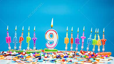Happy birthday candle letters with number nine on a beautiful blue background. Copy space Happy birthday greetings for 9 years old