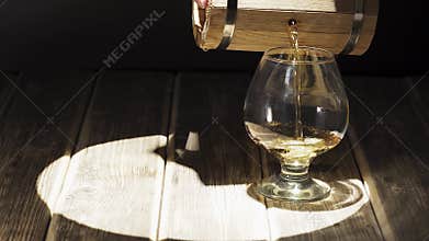Pouring homemade whiskey from a mini oak barrel, video slide