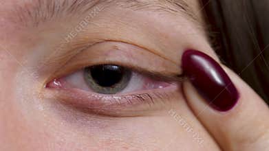 Pretty female with gray eye looking at camera and smiles, pupil with iris
